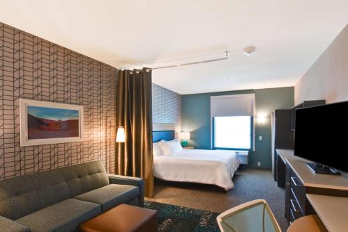 帕姆代尔棕榈谷希尔顿欣庭套房酒店的酒店客房,配有床和沙发