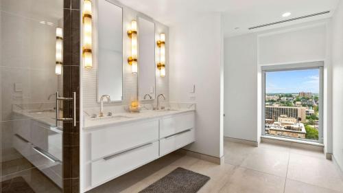 诺克斯维尔Embassy Suites By Hilton Knoxville Downtown的白色的浴室设有两个盥洗盆和窗户。