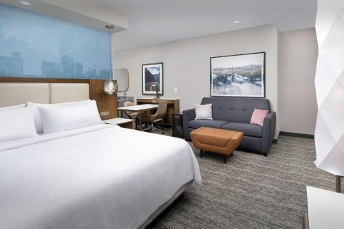 诺克斯维尔Embassy Suites By Hilton Knoxville Downtown的酒店客房,配有床和沙发