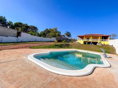 陶巴特Chacara com piscina, churrasq e WiFi em Taubate SP的一座带房子的庭院内的游泳池