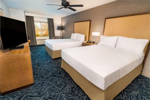 兰乔科尔多瓦Homewood Suites By Hilton Rancho Cordova, Ca的酒店客房设有两张床和一台平面电视。