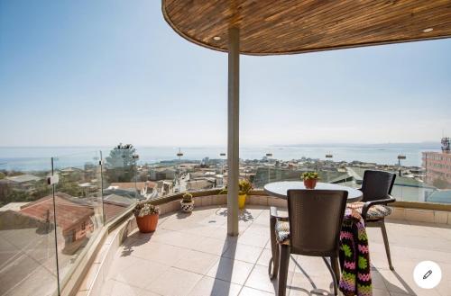 瓦尔帕莱索Hostal lala porteña vista al mar, baño privado y desayuno的阳台配有桌椅,享有海景。