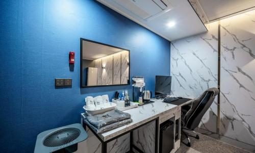 Tongduch'ŏnG7 Hotel的一个带蓝色墙壁、书桌和镜子的办公室