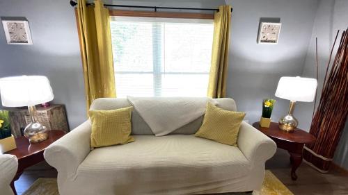 密尔沃基Luxx Guest House的客厅配有白色沙发和窗户