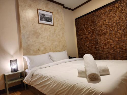 曼谷The Travellers House - Pet Friendly Accommodation的卧室配有白色床和毛巾