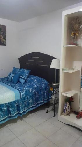 库斯科Q'entiHospedaje zaguan del cielo 2的一间卧室配有一张带蓝色床单和一盏灯的床。