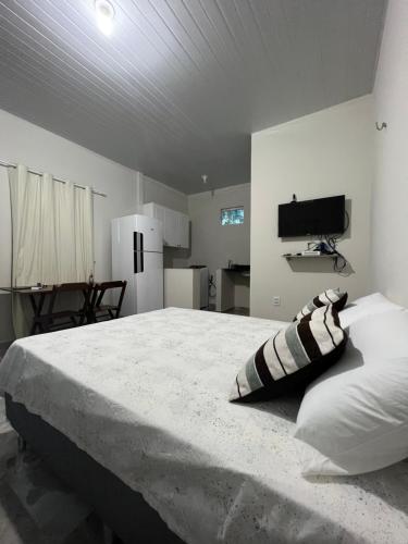 博阿维斯塔APARTAMENTO MOBILIADO的一间带大床的卧室和一间厨房