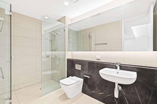悉尼One Bedroom with Roof Top Pool的浴室配有卫生间、盥洗盆和淋浴。