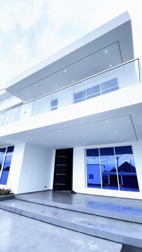 阿库雷Contemporary 4-Bedroom Villa with VR Room and Starlink Internet - Ifemide Estates的白色的房子,有黑色的门和窗户