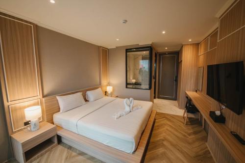 合艾Carrara Hotel Hatyai的一间卧室配有一张床和一台平面电视