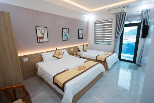 奠边府市HoTel Thịnh Vượng的酒店客房设有两张床和窗户。