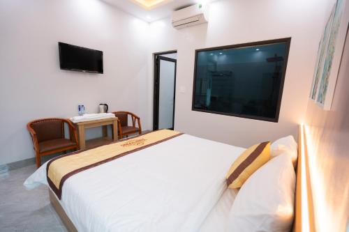 奠边府市HoTel Thịnh Vượng的卧室配有一张大床,墙上配有电视