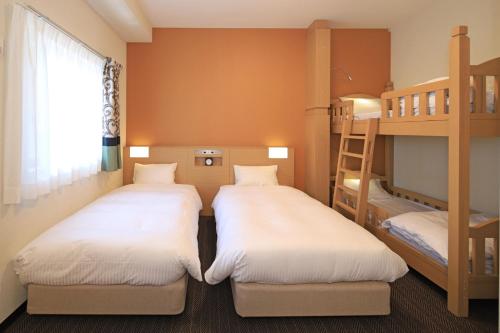 大阪Nest&Rise Osaka Namba Hotel的双层床间内的两张床