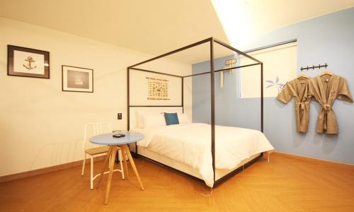 IksanIksan 4 Seasons Hotel的一间卧室配有一张床、一张桌子和一个衣架