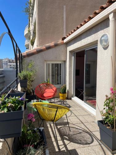 马赛Colourful loft in Marseille的天井配有桌椅和盆栽植物