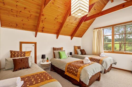 VentnorPerfect Getaway in Phillip Island的一间带三张床的卧室和木制天花板