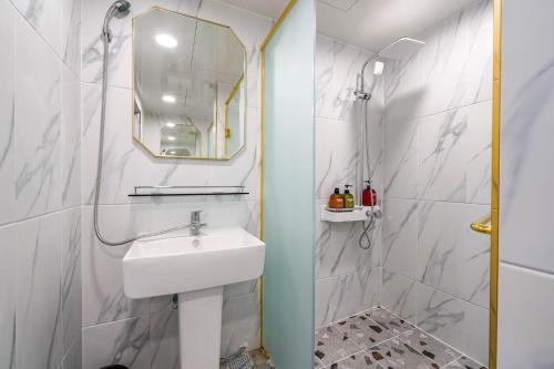 釜山Oops Hotel的白色的浴室设有水槽和镜子