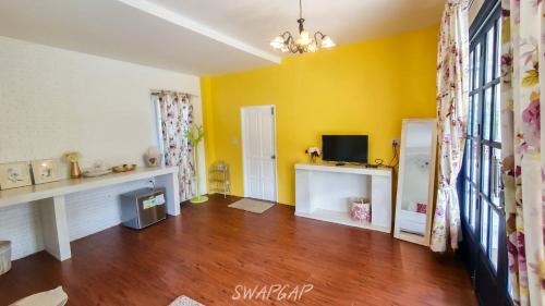 林信莱姆星白宫度假村的客厅拥有黄色的墙壁和木地板。