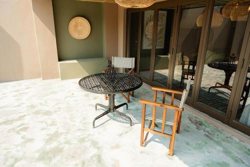 雾观Bambuu Lakeside Lodge的带庭院的客房内的一张桌子和两把椅子