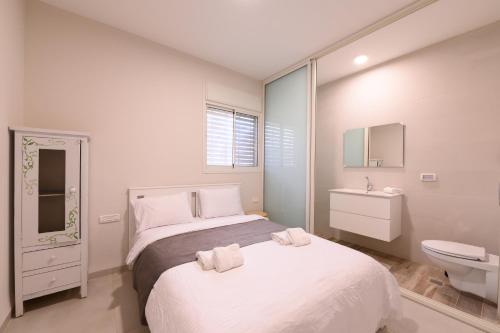 Shadmot Devoraדירת נופש מרחבים Merhavim Villa的一间卧室配有床、水槽和卫生间