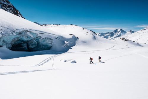 马索科托Aparthotel Maso Corto的两个人在雪覆盖的山里滑雪