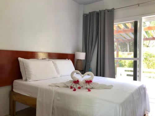 桑坦德Melbas Homestyle Resort & SPA的两个天鹅坐在床上