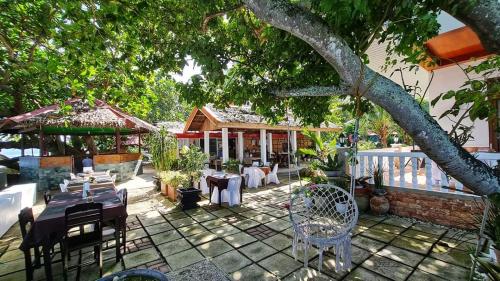 桑坦德Melbas Homestyle Resort & SPA的房屋前设有带桌椅的天井。