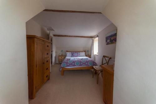 斯特劳德Traditional Cotswold Stone Peaceful Cottage with stunning views的一间卧室配有一张床和一个木制梳妆台