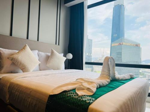 吉隆坡AXON Suites Bukit Bintang By Sky Pool的躺在窗前床边的女人