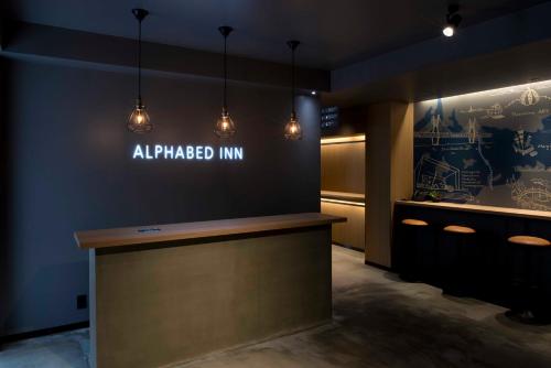 高松ALPHABED INN Takamatsuekimae的灯火通明的房间里所有标记的旅馆标志