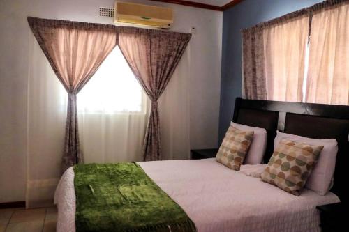 卡萨内Yaxida's Warmth的一间卧室配有床和带窗帘的窗户