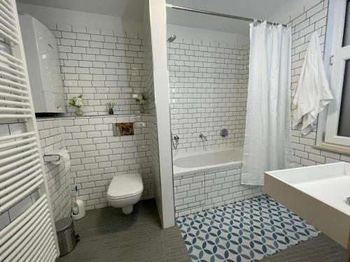 布鲁塞尔Apartament的浴室配有卫生间、浴缸和水槽。