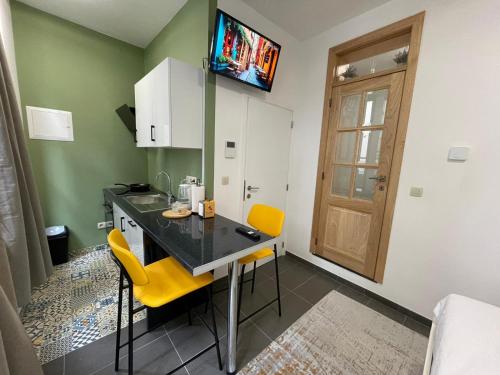 布鲁塞尔Apartament的厨房配有桌子和2把黄色椅子