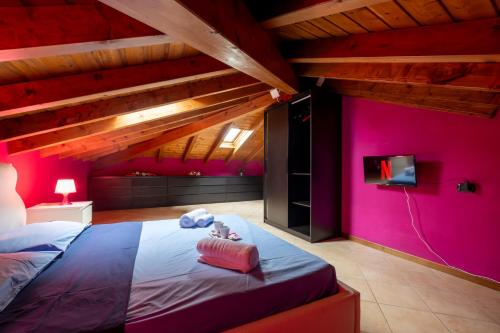 塞斯托卡伦德[Leonardo Academy in 5'] MXP, Laghi & Wi-Fi的一间卧室设有粉红色的墙壁和一张带电视的床。