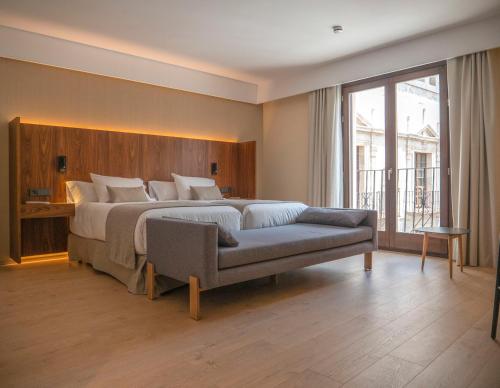 特鲁埃尔Hotel Palacio La Marquesa 4 Estrellas SUP的一间卧室配有一张大床和一张沙发