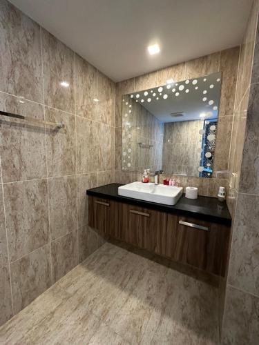 芭堤雅市中心Large Deluxe Condo Grand Avenue Central Pattaya的一间带水槽和镜子的浴室