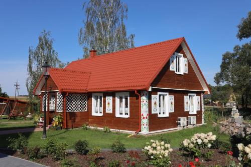 Dąbrowa Grodzieńska-WieśHarasimówka的一座橙色屋顶房屋的模型