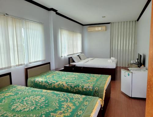 Ban Bang Kra叻丕府塔拉Spa度假村的酒店客房设有两张床和电视。