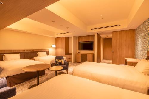 札幌Hotel Emion Sapporo的酒店客房设有两张床和电视。