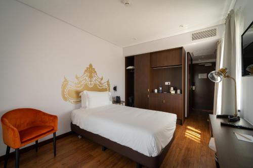 英雄港Palacio Santa Catarina Hotel的卧室配有白色的床和橙色椅子
