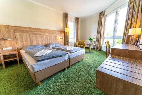 文迪施里茨Einklang - Dein Hotel am Südhorn的酒店客房带一张床、一张桌子和椅子