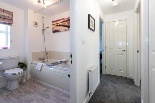 曼彻斯特Beautifully designed 3 Bed House - in Manchester的带浴缸、卫生间和盥洗盆的浴室