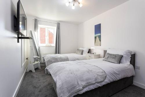 曼彻斯特Beautifully designed 3 Bed House - in Manchester的一间白色卧室,配有两张床和窗户