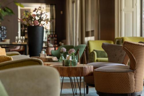 多廷赫姆鲁因兹赫别墅酒店的大堂配有桌椅和鲜花