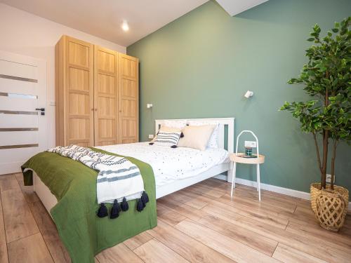 达布罗瓦古尔尼恰OAK TREE Apartment的一间卧室设有一张床和绿色的墙壁