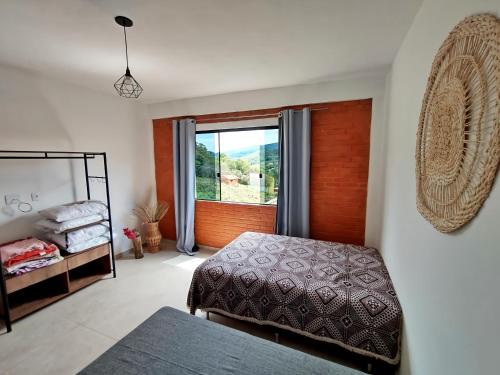 康塞高伊比蒂波卡Casa Amantes da Serra Ibitipoca - Sua melhor opção!的一间卧室设有两张床和大窗户