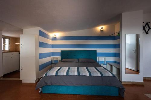 马纳罗拉Sunset Manarola的一间卧室配有一张蓝色和白色条纹的床