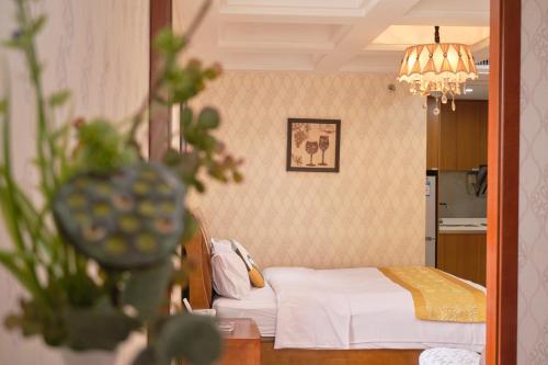 广州广州友家服务公寓的一间卧室配有一张床和一个吊灯