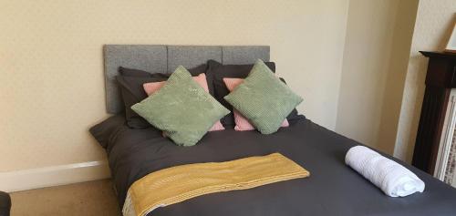 考文垂Coventry Spacious Rooms In City的一张带粉色和绿色枕头的床