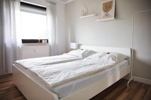 兰河畔马尔堡DG-Wohnung mit sonnigem Balkon的白色卧室内的一张白色床,设有窗户